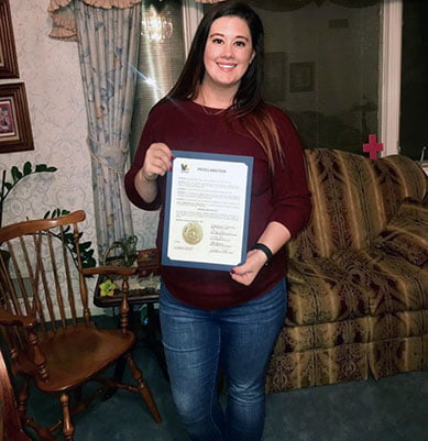 Anastasia Schroeder ’15 Schroeder '15 with signed petition from the mayor of Kearney, announcing National Adoption Day