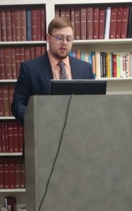 Photo of Austin Heinlein giving a presentation at a podium.