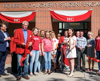 Student cutting a ribbon for a building dedication.