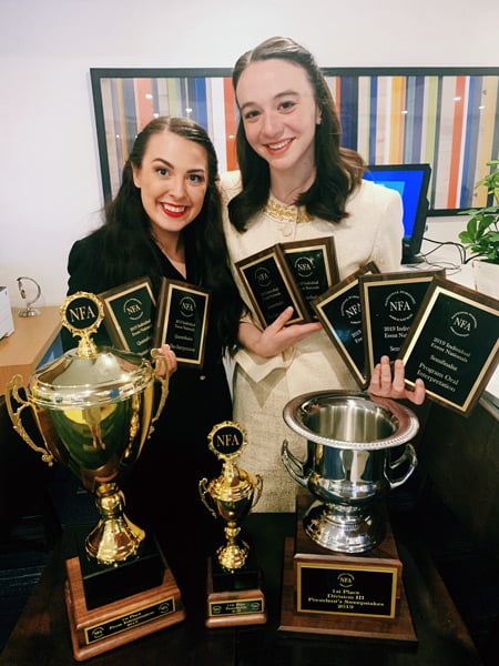 A photo of Alli Kennon and Carly Spotts-Falzone with trophies.