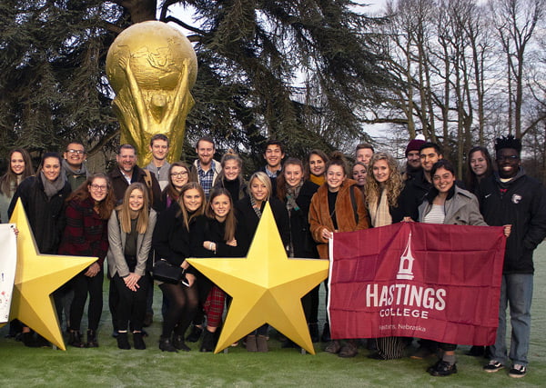 Students lined up on the lawn outside a soccer facility in France.