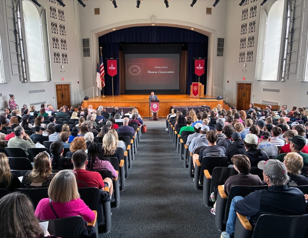 Photo of people sitting and the chapel stage.