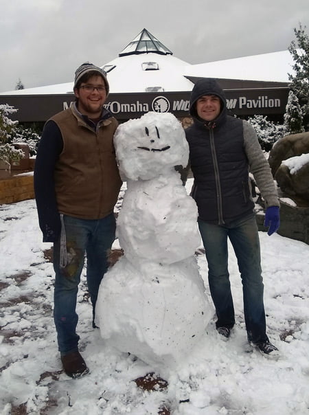 Two students with a snowman they built.