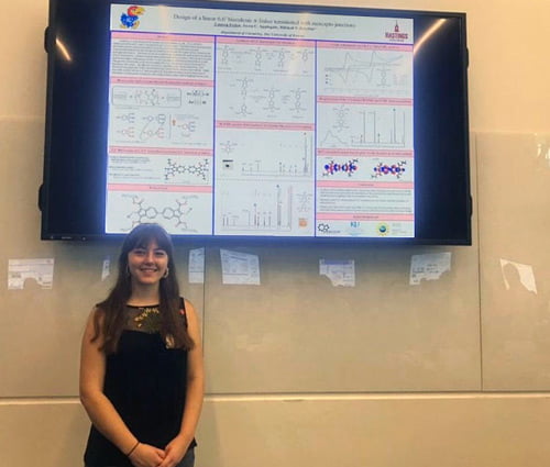 Student in front of a scientific poster