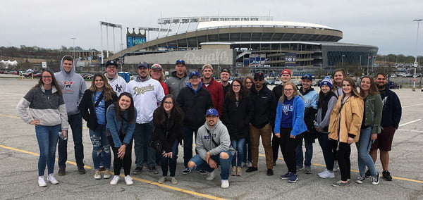 Students posed for a photo in a parking lot.