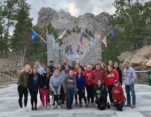 Students pose for a picture in front of Mount Rushmore.