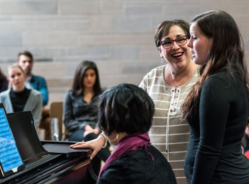 Dr. Hillary Watter working with a student who is singing.