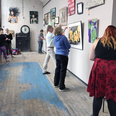 Students in a gallery hanging art for a show.