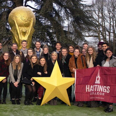 Students lined up on the lawn outside a soccer facility in France.