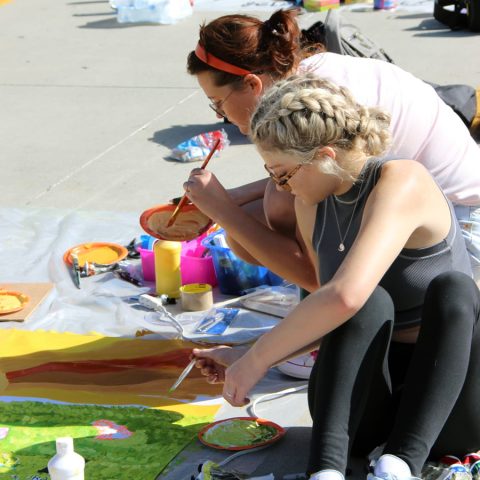 Students work on a mural during the 2023 Mural Competition at Hastings College.