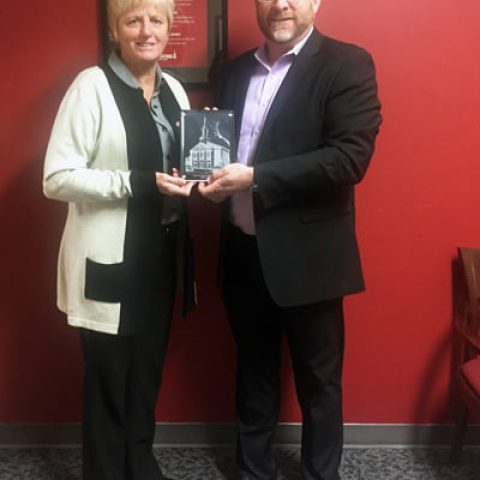 Photo of two individuals with an award.