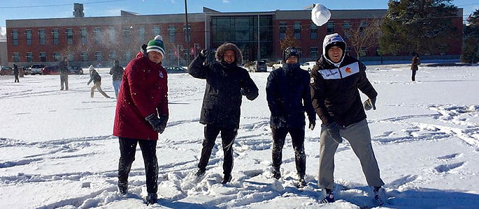 Students throwing snowballs in the winter